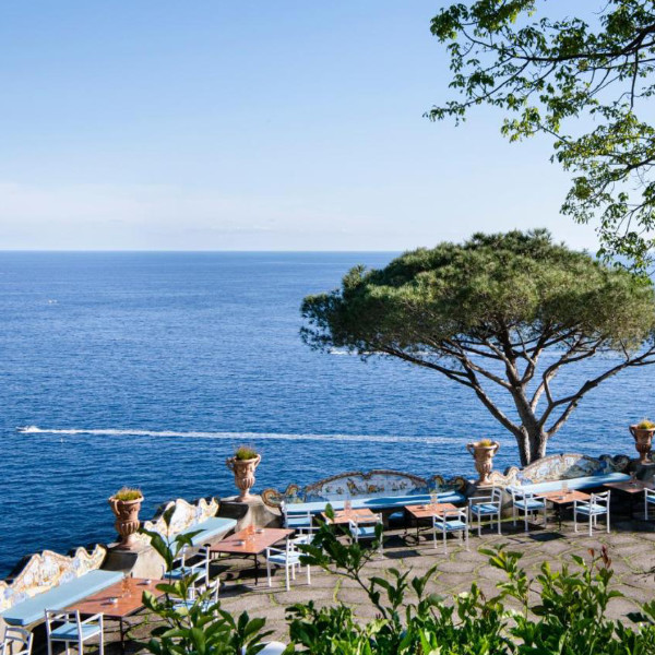 Terrasse de l’Hotel San Pietro à Positano avec tables et vue panoramique sur la mer.