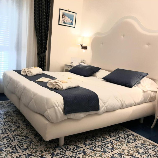 Chambre élégante de l'Hôtel Santa Lucia avec sol en faïence traditionnelle bleue.