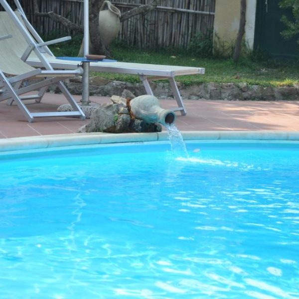 Piscine azur avec fontaine décorative pour les clients de l'Hôtel Savoia de Procida.