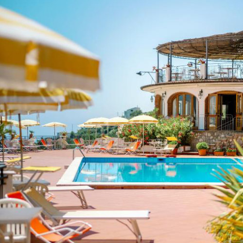Piscine de l'Hôtel Villa Giuseppina avec parasols jaunes et terrasse à Scala.