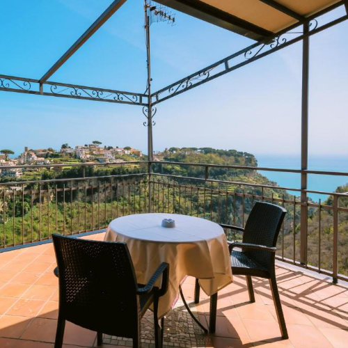 Terrasse privée avec table et chaises dominant le village et la mer à Scala.