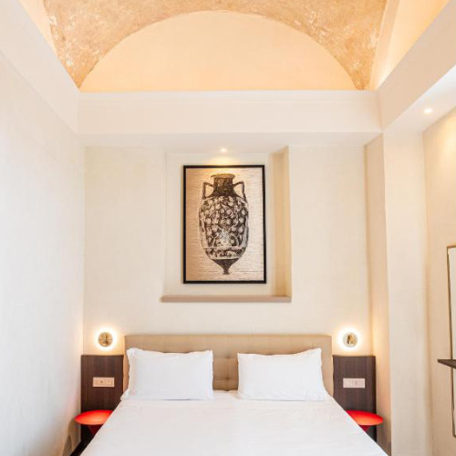 Chambre élégante avec plafond voûté et décor antique à l'Hôtel Vittoria.