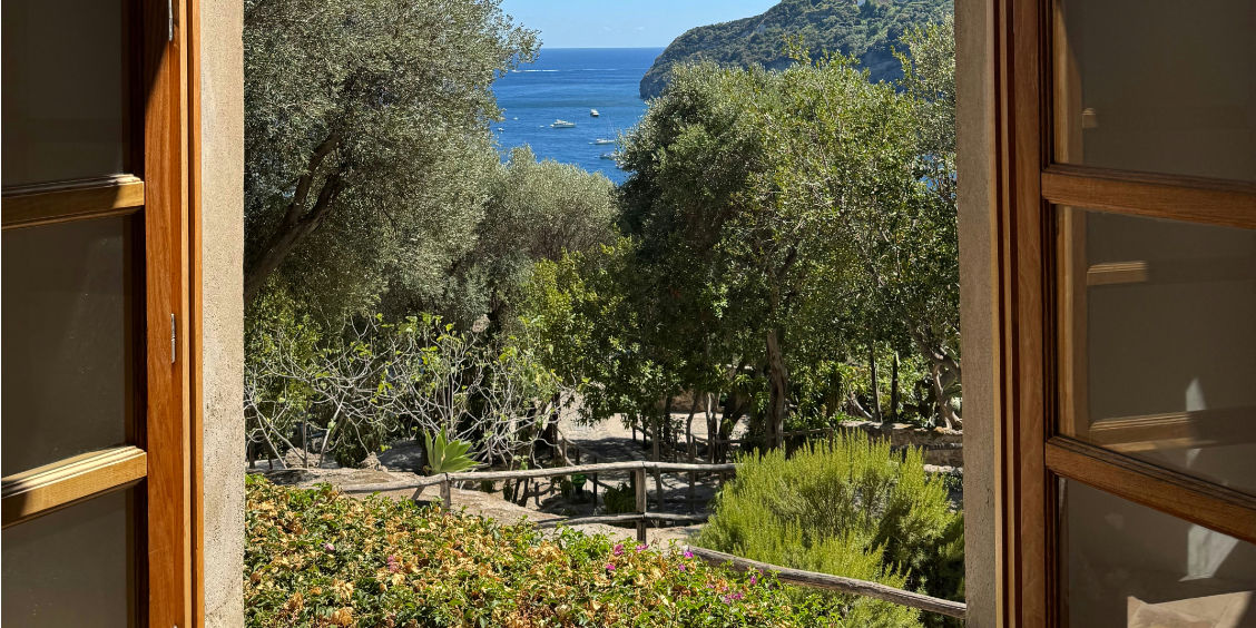 Vue sur la mer et les jardins depuis une fenêtre à Ischia.