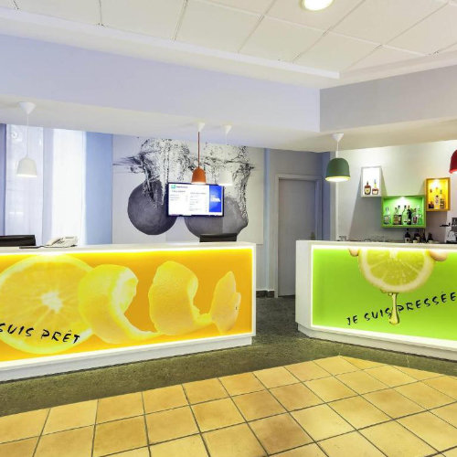 Espace réception au design moderne et vitaminé avec des comptoirs colorés illustrés de citrons.