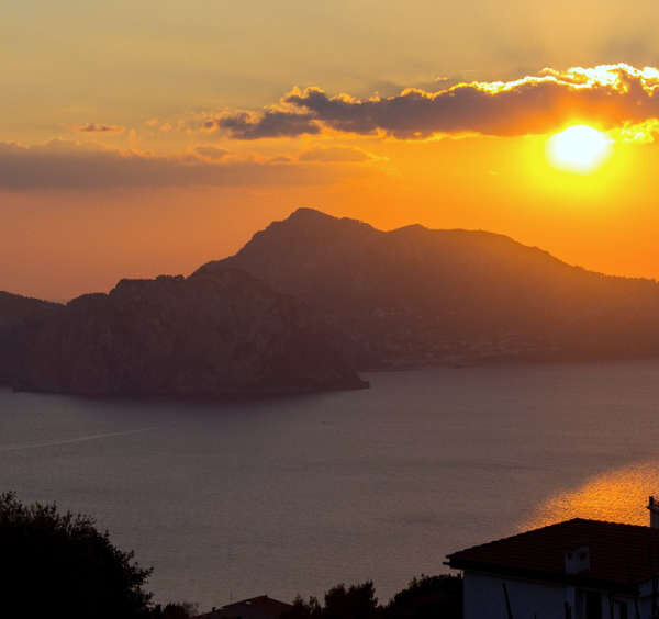 Vue panoramique spectaculaire de l'île de Capri en Italie avec la silhouette des rochers Faraglioni au coucher du soleil.
