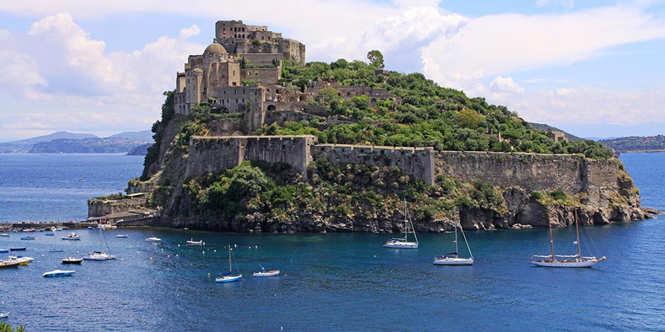 Île d’Ischia avec le château aragonais sur un îlot rocheux entouré par la mer.