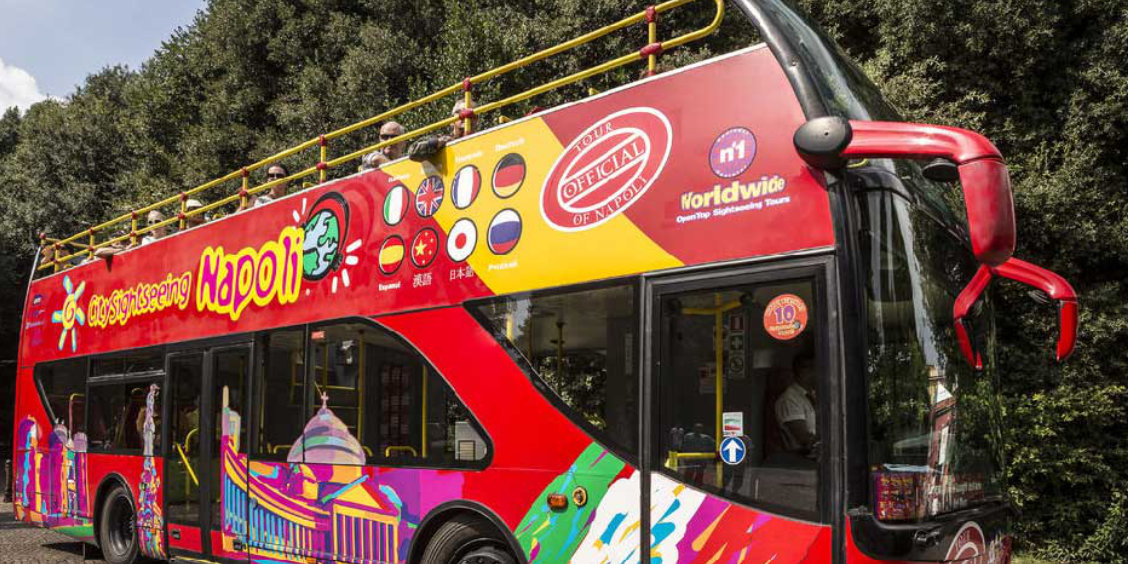 Bus touristique panoramique à Naples avec toit ouvert, utilisé pour découvrir les principaux monuments.