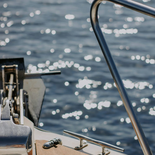 Détail de la proue d'un bateau avec son ancre sur une mer scintillante à Ischia Porto.