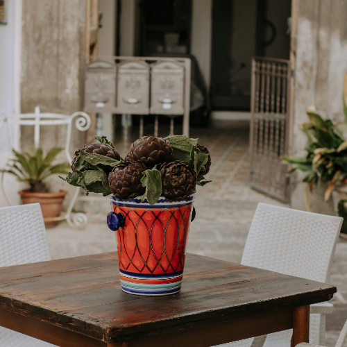 Artichauts disposés dans un vase en céramique colorée sur une terrasse à Ischia Porto.