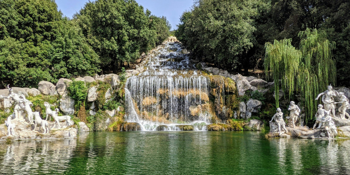 Jardins du Palais royal de Caserte avec cascade, bassin et statues monumentales.