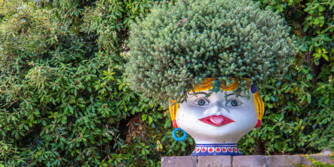 Pot décoratif en forme de tête dans un jardin de Sorrente en juillet.