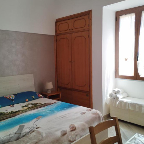 Chambre lumineuse de La Casetta di Mary avec mobilier en bois et décoration marine.