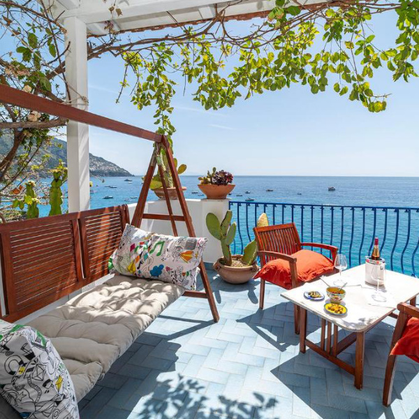 Terrasse de La Dolce Vita à Positano avec salon extérieur et vue sur la mer.