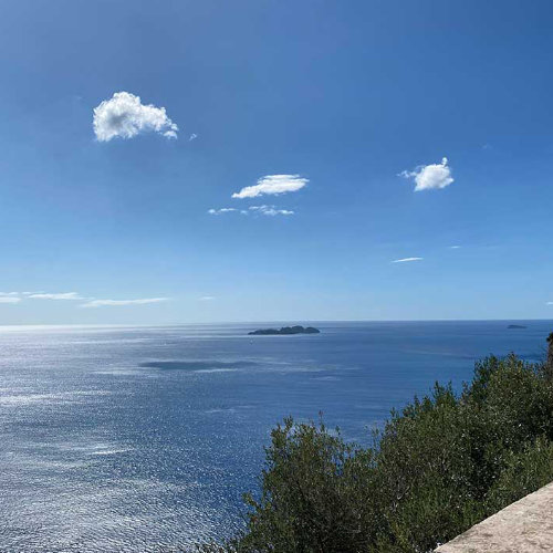 Vue panoramique sur les îles Li Galli depuis la Côte Amalfitaine sous ciel bleu.