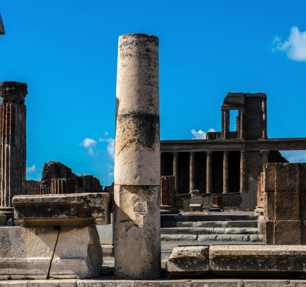 Colonnes romaines et espaces publics au cœur du site archéologique de Pompéi.