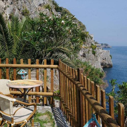 Terrasse de la Locanda Fiordo à Furore avec table et panorama sur la côte.
