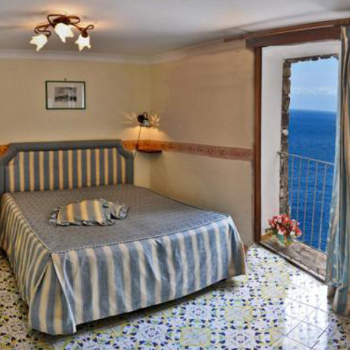 Chambre de la Locanda Fiordo à Furore avec balcon ouvert sur la mer.