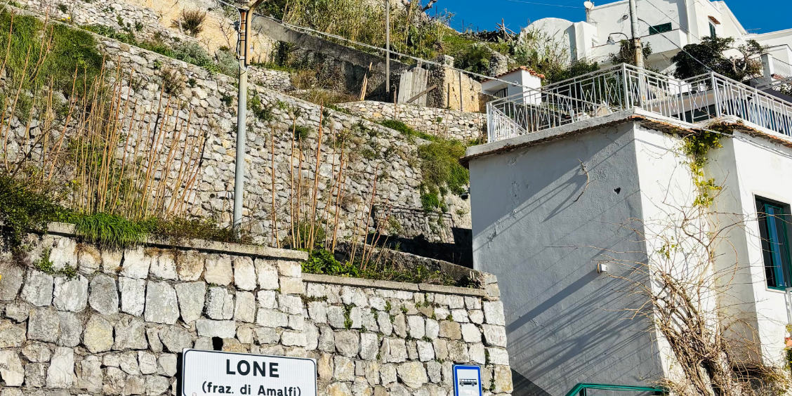 Hameau de Lone à Amalfi avec maisons blanches, terrasses et murs en pierre.