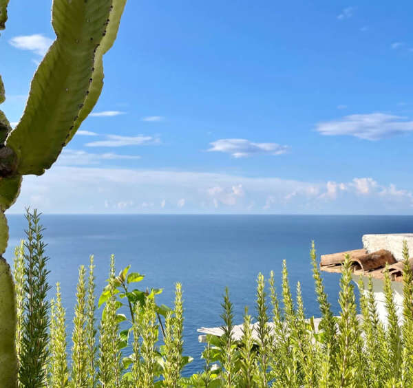 Terrasse typique d'un hébergement sur la Côte Amalfitaine avec vue imprenabile sur l'horizon et la mer bleue.