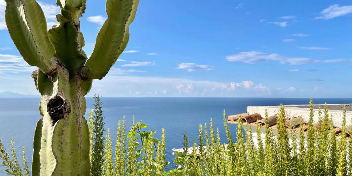 Terrasse typique d'un hébergement sur la Côte Amalfitaine avec vue imprenabile sur l'horizon et la mer bleue.