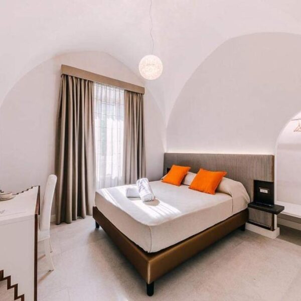 Chambre lumineuse du Maera B&B à Ravello avec lit double et plafond voûté.