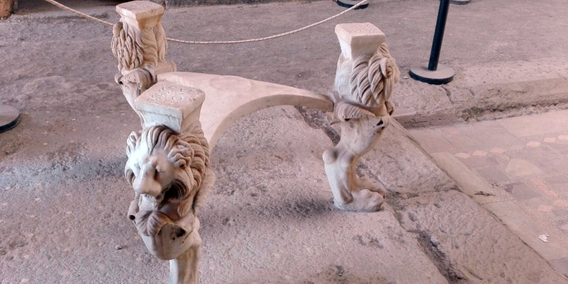 Table en marbre antique (cartibulum) dont les trois pieds sont sculptés en forme de têtes et de pattes de lion, située dans la Maison de Casca Longus à Pompéi.