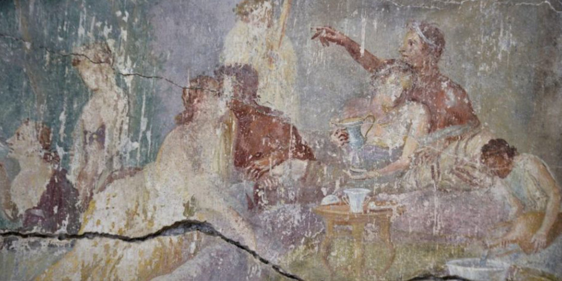 Fresque murale de la Maison des Chastes Amants à Pompéi représentant plusieurs personnages lors d'un banquet, avec un couple s'embrassant sur la gauche.
