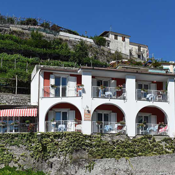 Façade blanche à arches de la Maison Raphael nichée au cœur des vignobles en terrasse de Minori.