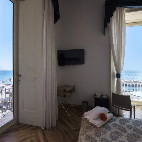 Chambre avec balcons vue mer panoramique sur le Castel dell'Ovo et le front de mer napolitain.