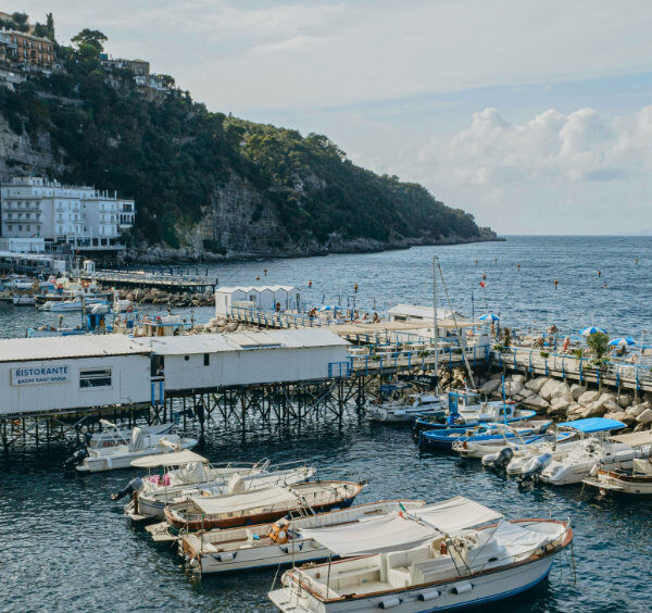 Marina Grande à Sorrente avec bateaux de pêche, pontons et restaurants au bord de la mer.