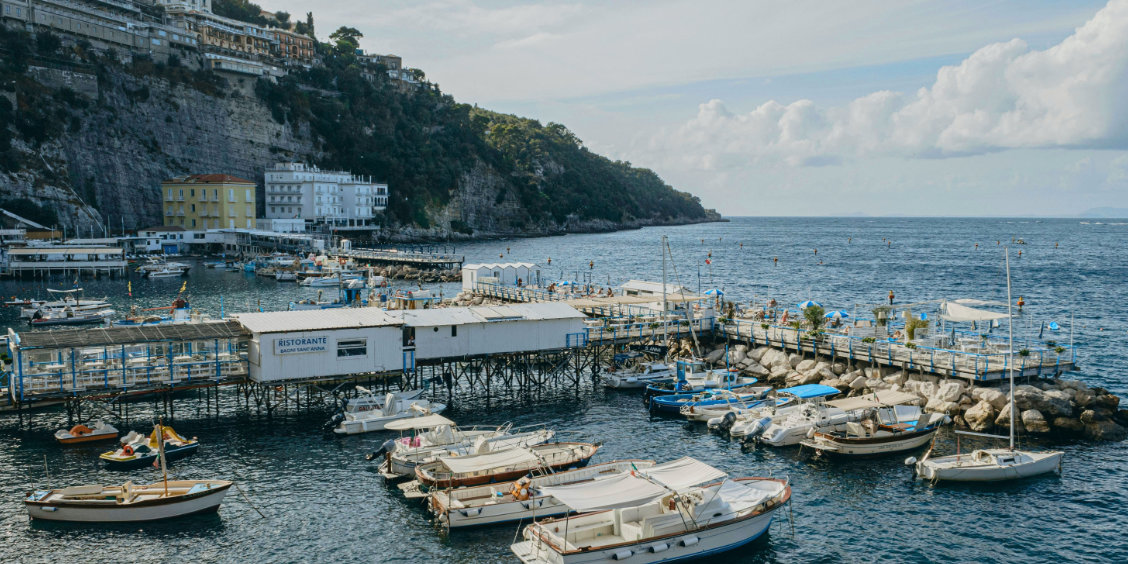 Marina Grande à Sorrente avec bateaux de pêche, pontons et restaurants au bord de la mer.