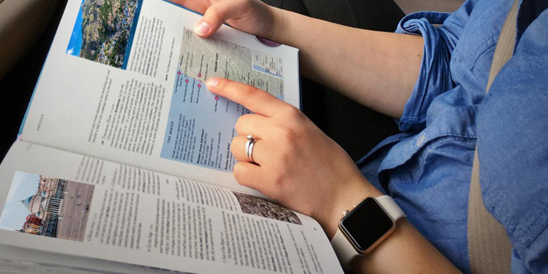 Guide de voyage sur Sorrente consulté pendant un trajet, avec carte et informations touristiques.