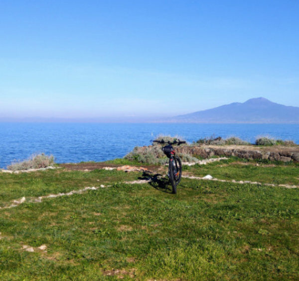 Point de vue panoramique à Sorrente avec vélo, mer bleue et Vésuve à l’horizon.