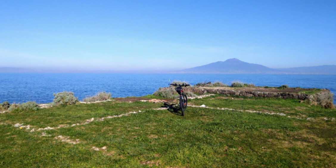 Point de vue panoramique à Sorrente avec vélo, mer bleue et Vésuve à l’horizon.