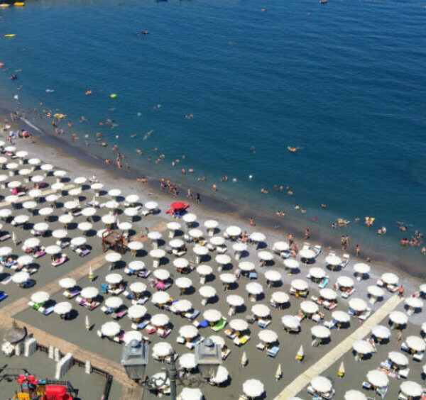 Plage de Meta sur la côte de Sorrente, avec parasols, baigneurs et mer bleue en Campanie.