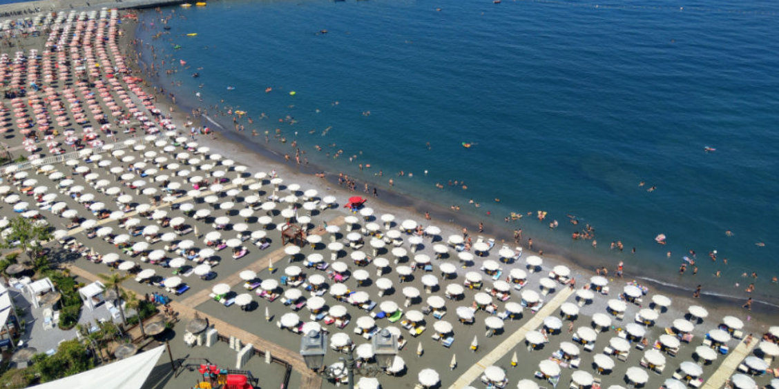 Plage de Meta sur la côte de Sorrente, avec parasols, baigneurs et mer bleue en Campanie.