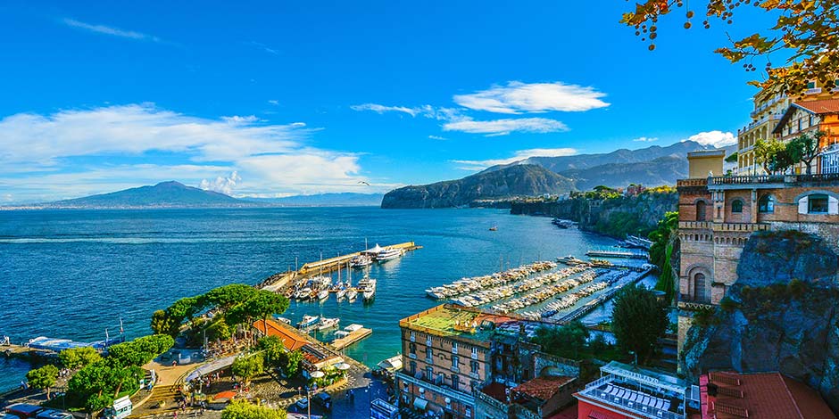 Port de Sorrente en avril avec bateaux, mer bleue et Vésuve à l’horizon.