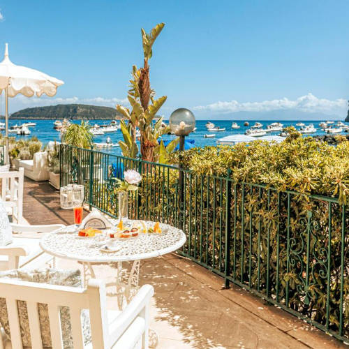 Terrasse de l'hôtel avec vue panoramique sur la baie et les bateaux.