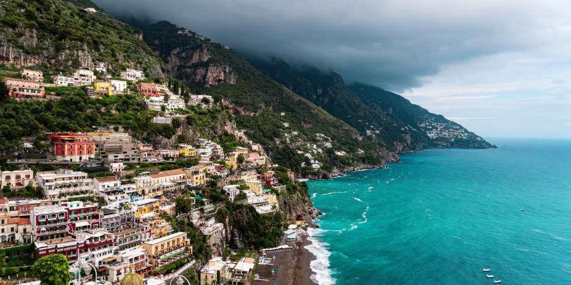 Falaises de Positano et mer turquoise sous d'épais nuages d'orage en automne.