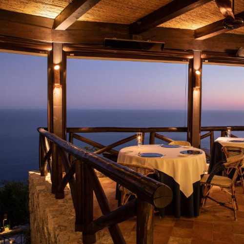 Terrasse du restaurant gastronomique face à la mer au crépuscule à Conca dei Marini.