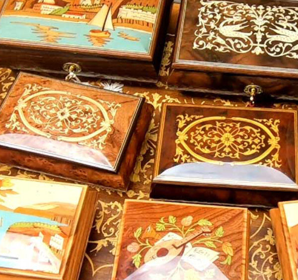 Boîtes artisanales en marqueterie de Sorrente avec motifs décoratifs et paysages colorés.