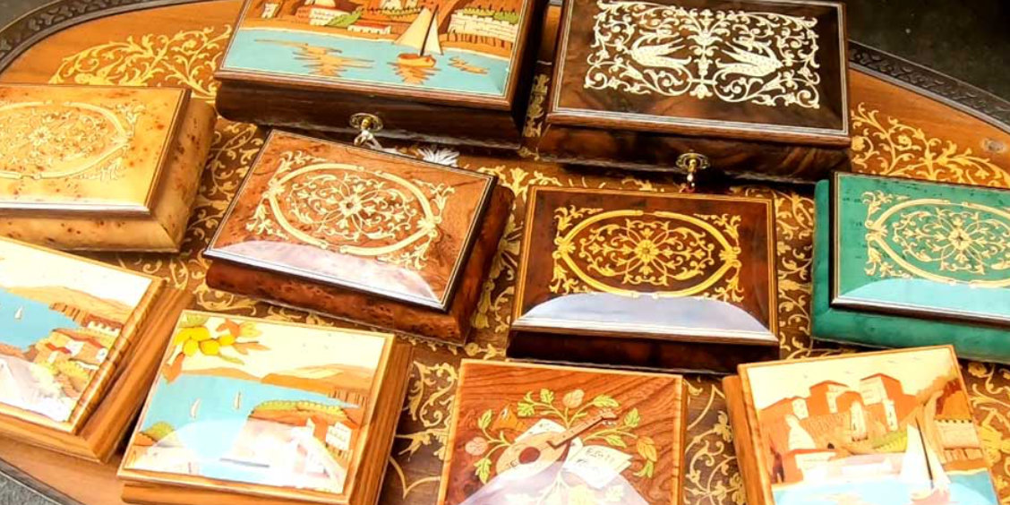 Boîtes artisanales en marqueterie de Sorrente avec motifs décoratifs et paysages colorés.