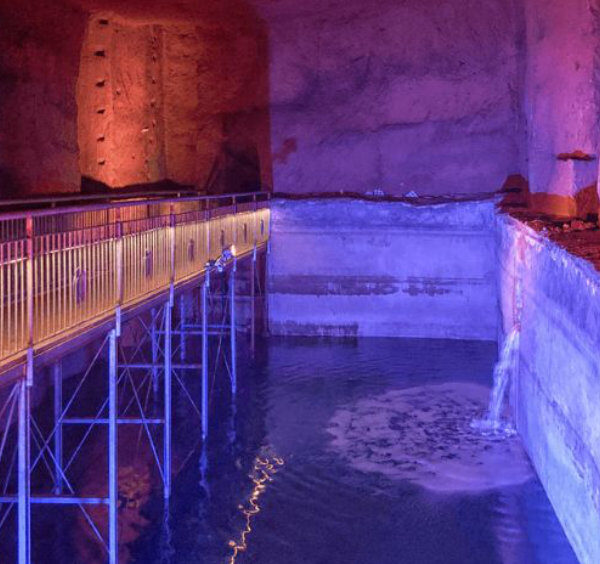Musée Lapis à Naples avec citerne souterraine, passerelle et éclairage coloré dans les galeries historiques