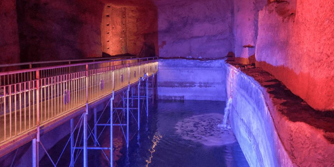 Musée Lapis à Naples avec citerne souterraine, passerelle et éclairage coloré dans les galeries historiques
