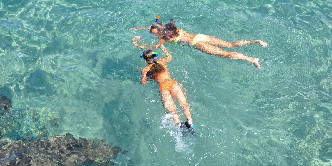 Nageurs avec masques de snorkeling dans l’eau claire près de Sorrente.