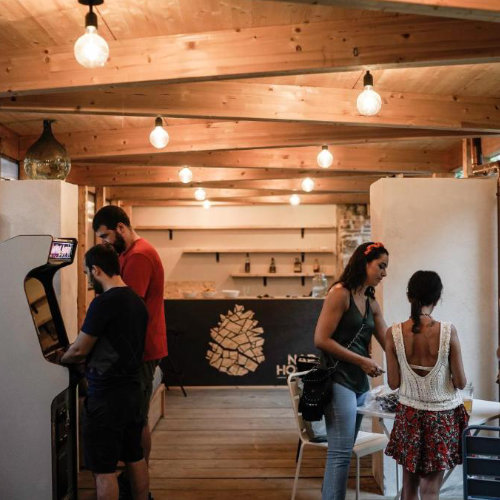 Espace intérieur convivial avec voyageurs dans un jardin, ambiance détendue et sociale à Naples.