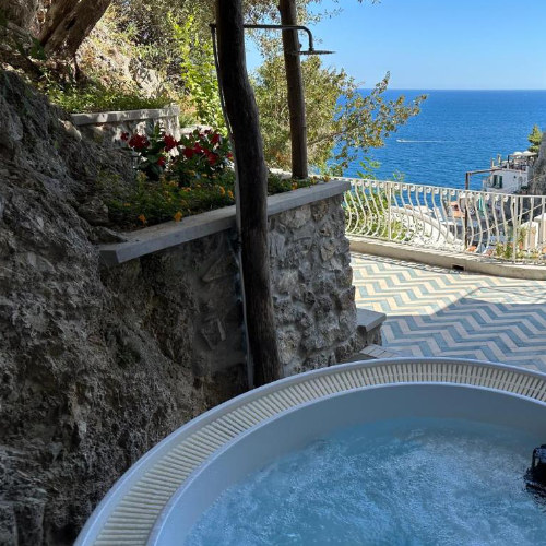 O Mar Amalfi Coast Suites à Praiano avec jacuzzi extérieur et vue sur la mer.