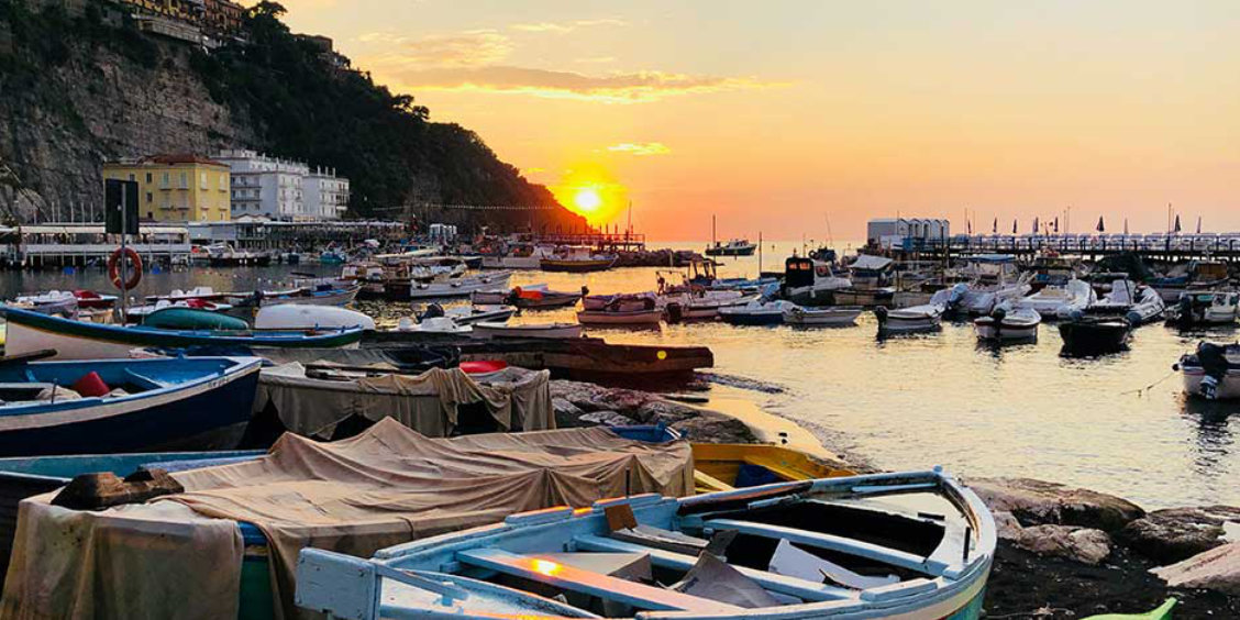 Marina Grande à Sorrente en octobre avec bateaux de pêche et coucher de soleil sur la mer.
