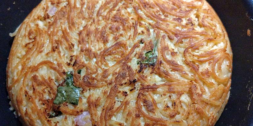 Frittata di pasta (omelette de pâtes) napolitaine dorée et croustillante, une spécialité typique de la cuisine de rue.
