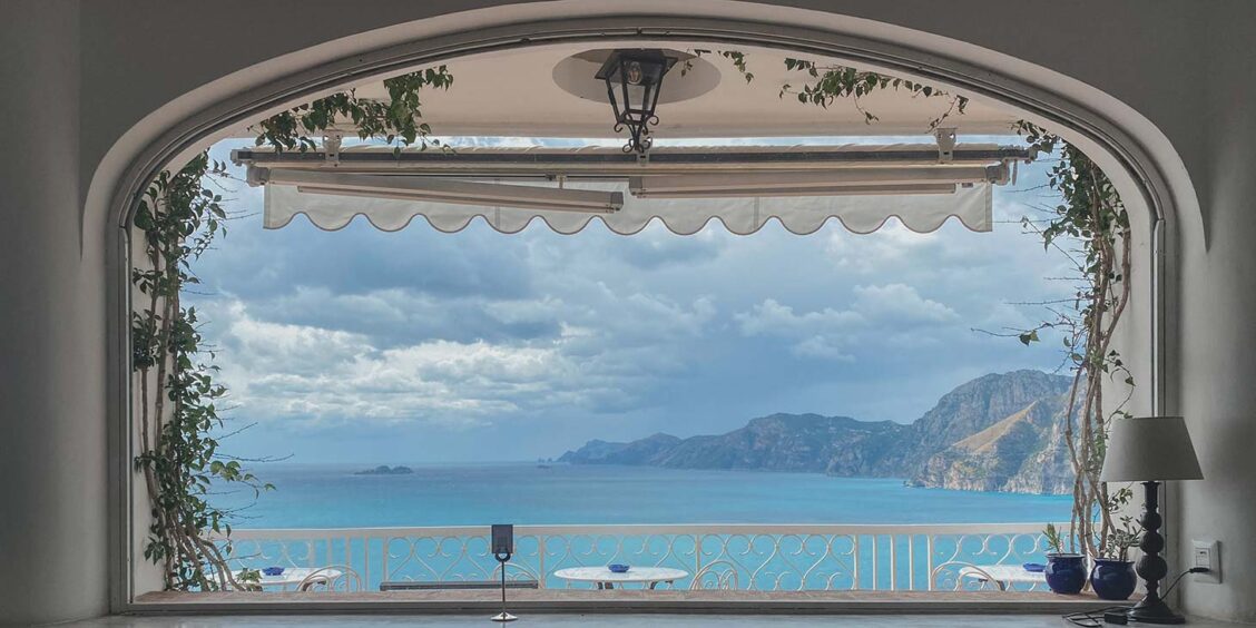 Vue sur la mer et les falaises de la Côte Amalfitaine depuis une terrasse panoramique.